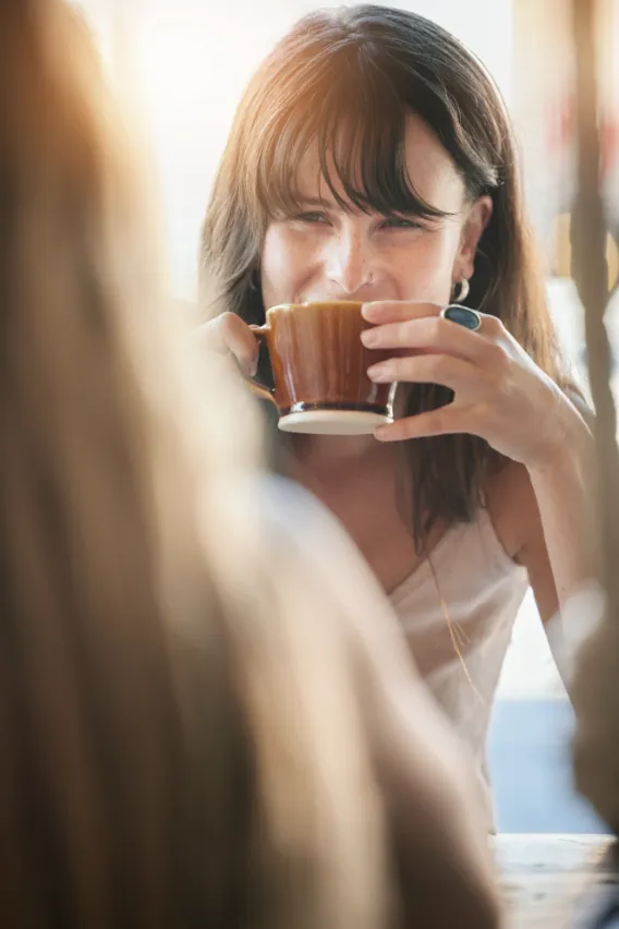 Woman smiling while drinking coffee